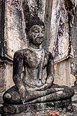 Thailand - Old Sukhothai - Wat Saphan Hin. the small statue of a seated Buddha in the  calling the Earth to witness  mudra. 